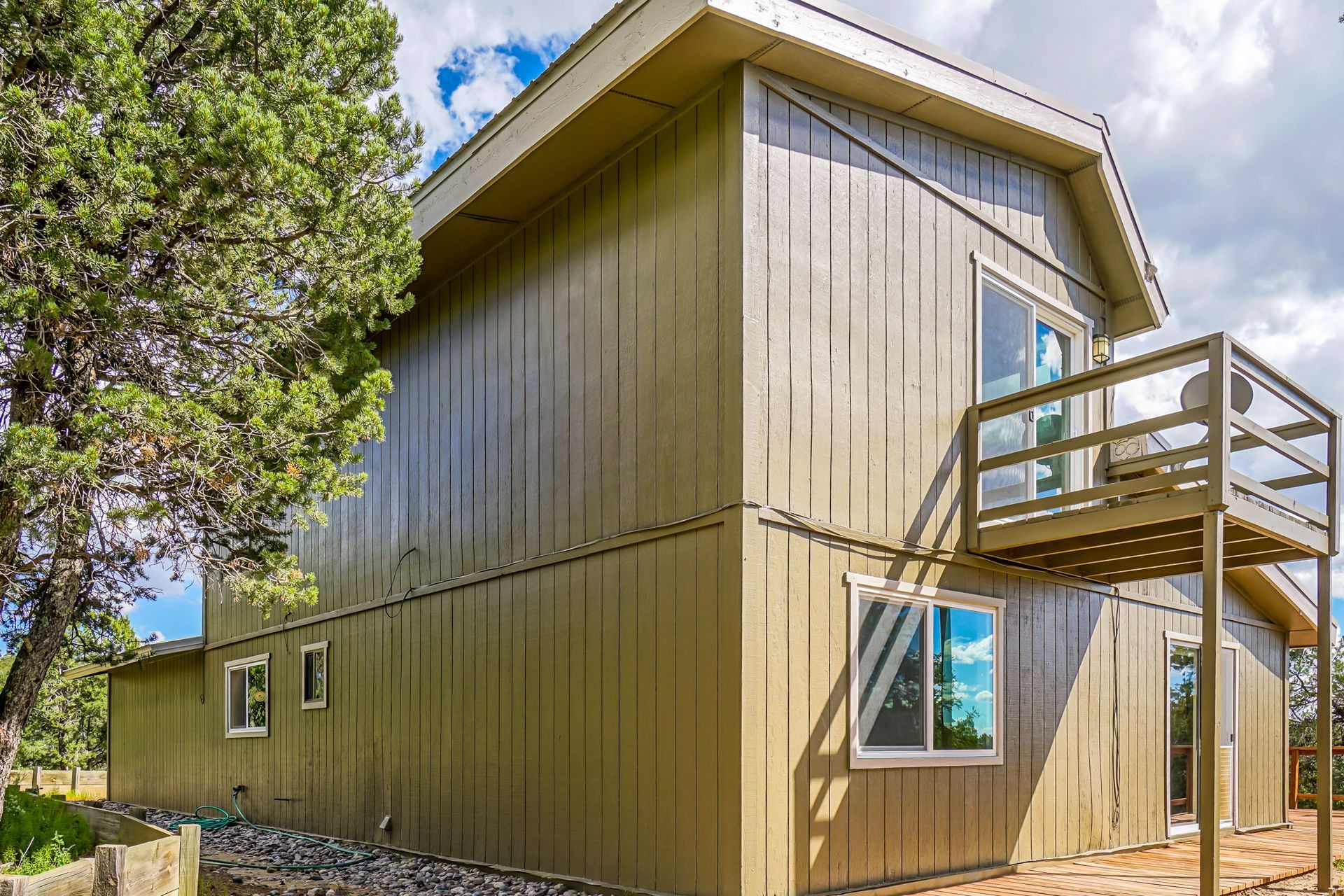 a house with a deck and stairs on the side of it .