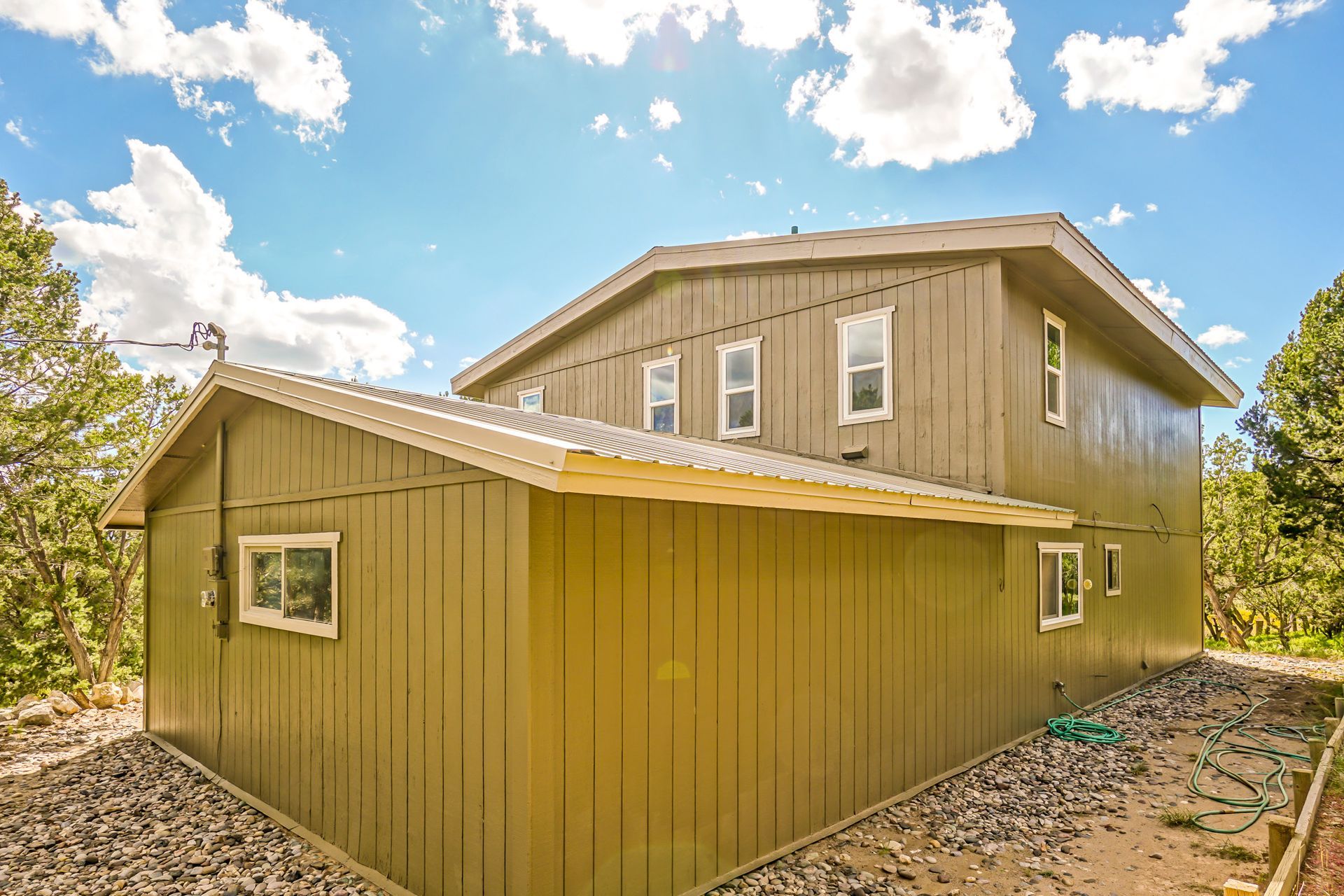 a large green house with a shed attached to it .