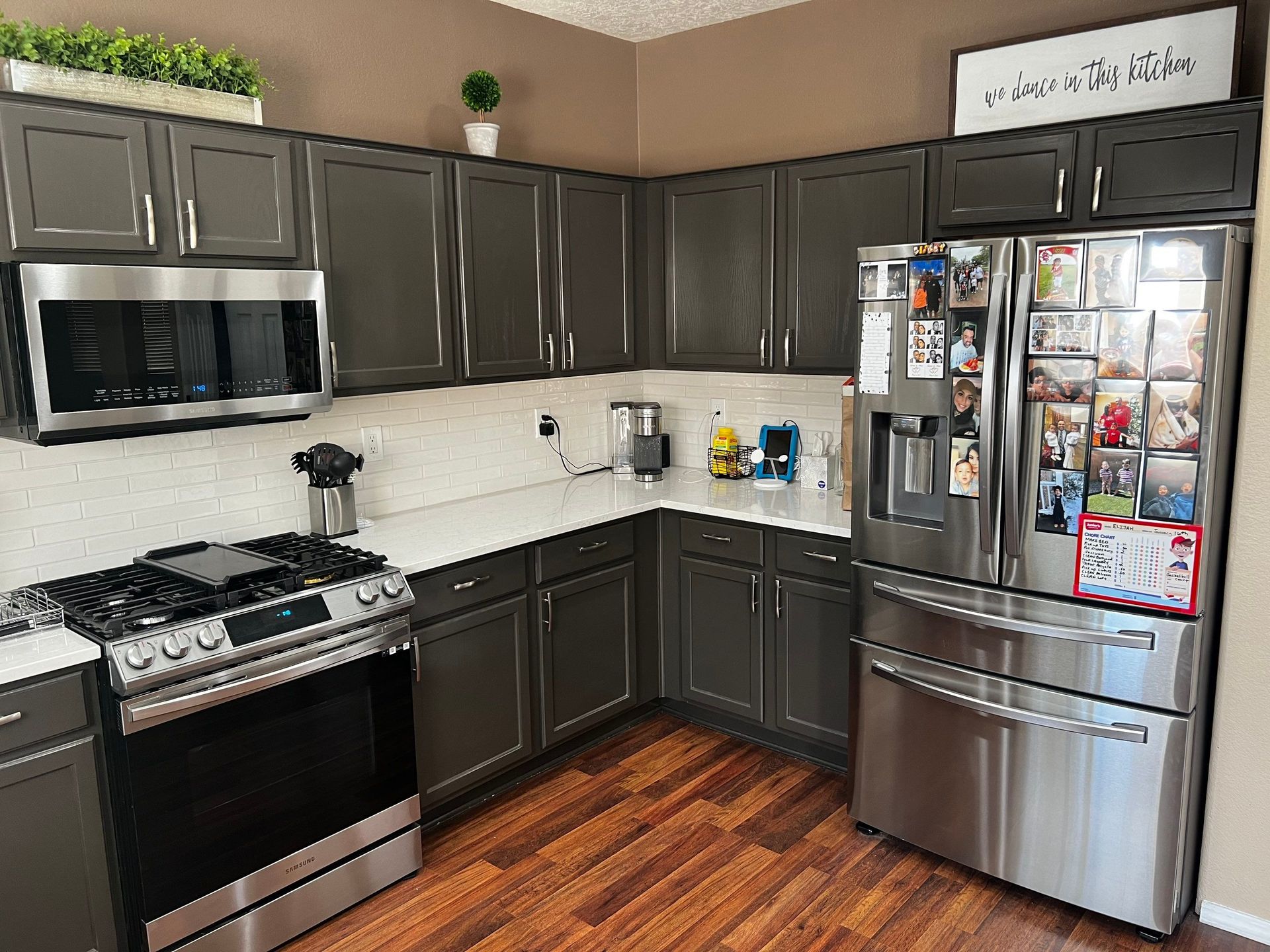 a kitchen with stainless steel appliances and gray cabinets .