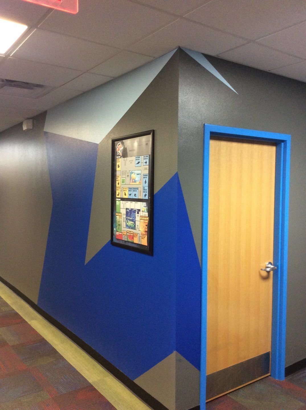 a hallway with blue and gray walls and a door