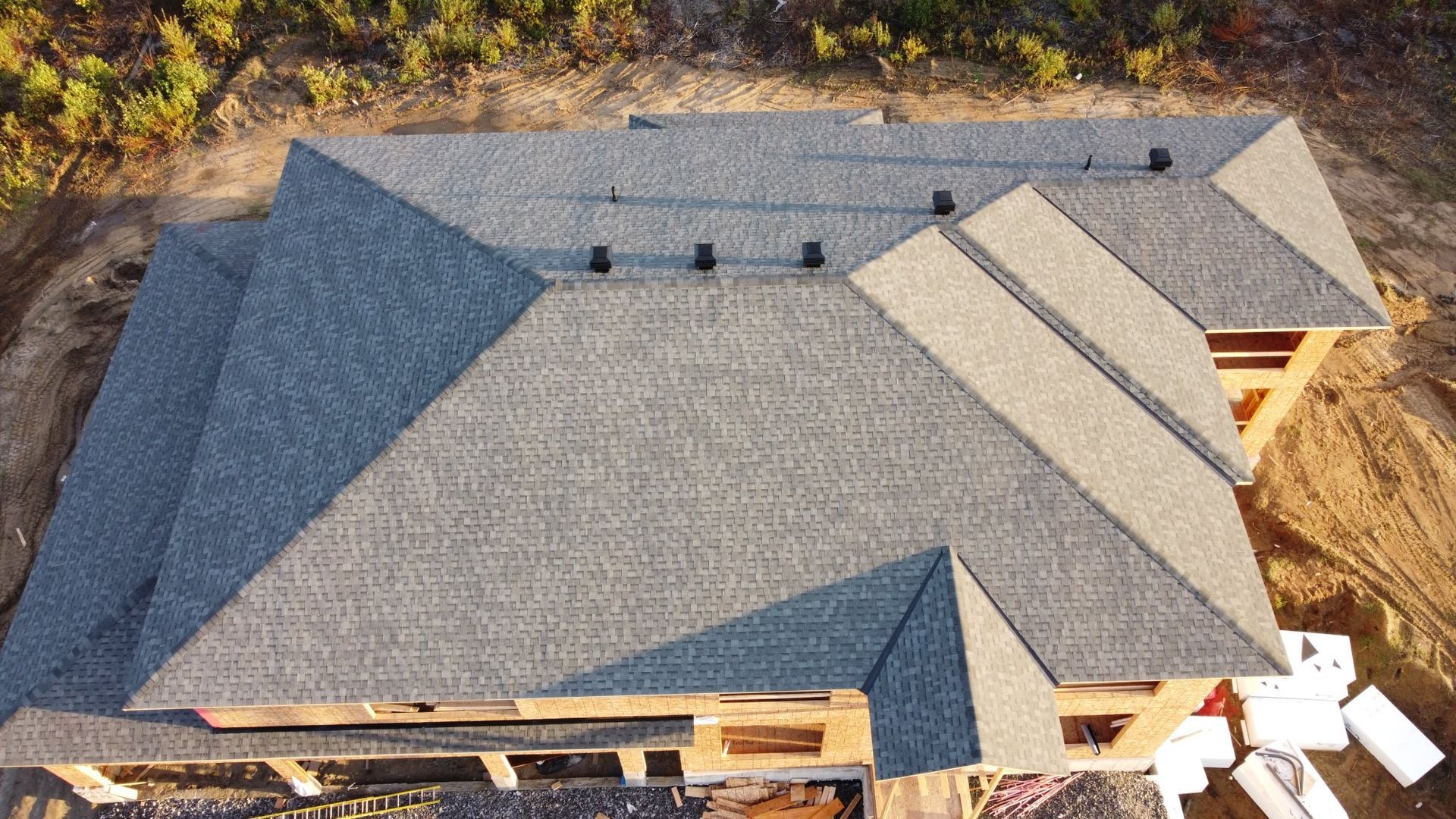 Une vue aérienne d'une maison en construction avec un toit en cours d'installation.