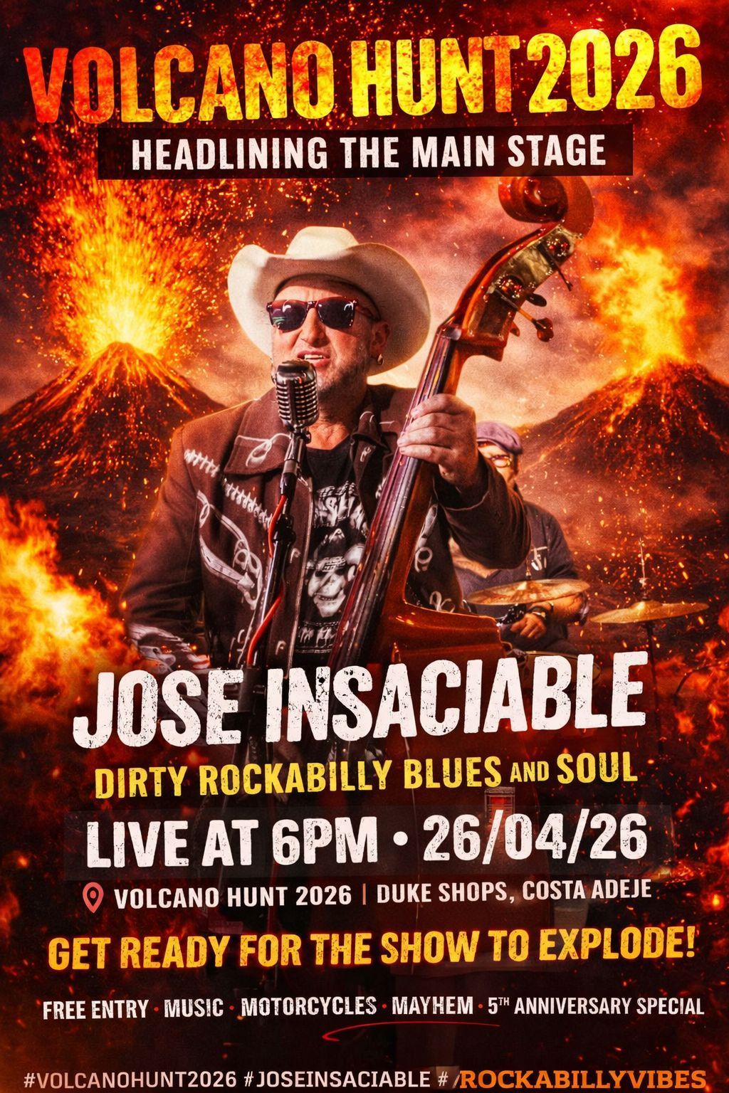 Two men on stage, one singing into a microphone, the other playing a stand-up bass. Red and blue stage lighting.