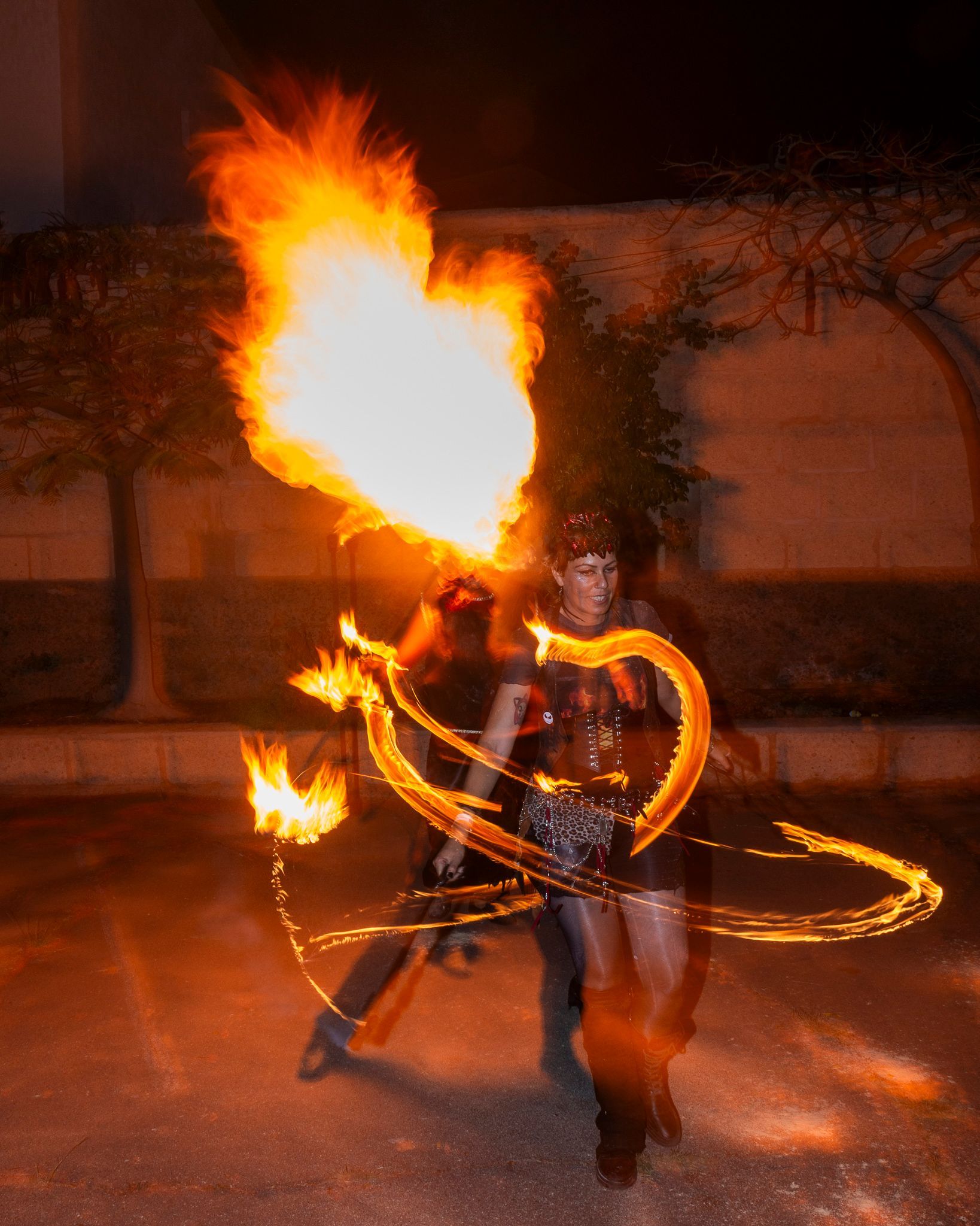 A woman is holding a heart shaped fire hoop