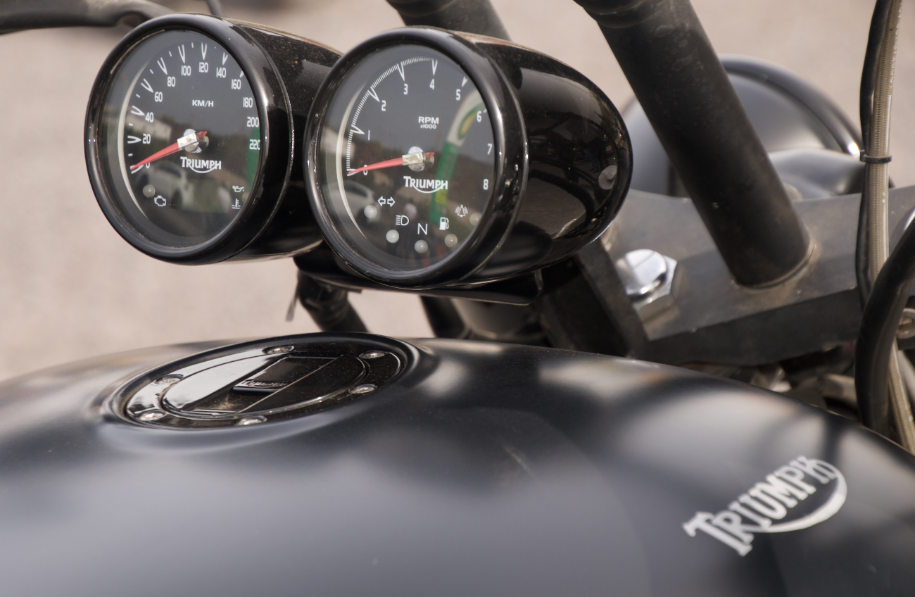 A close up of a triumph motorcycle with two speedometers