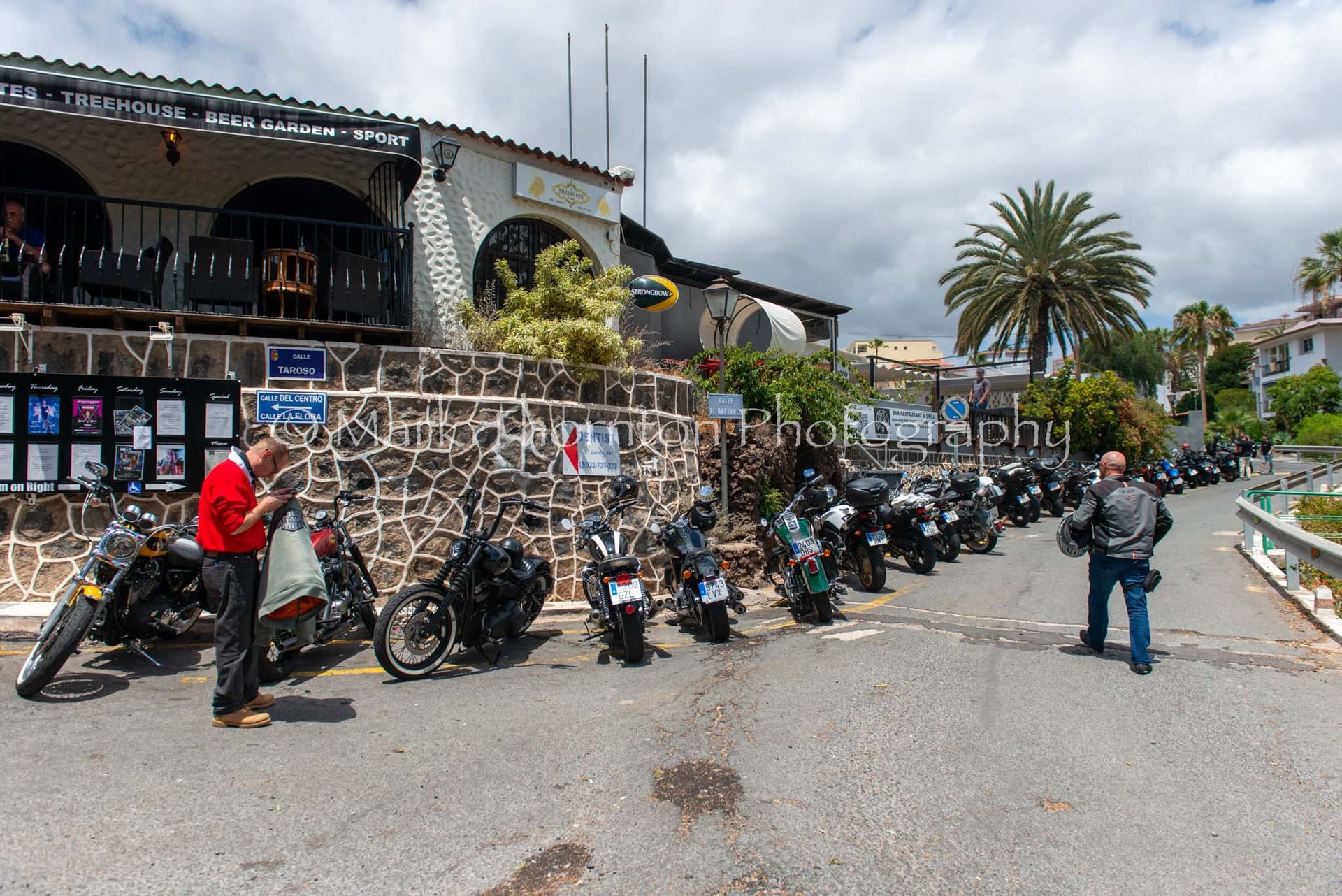 A row of motorcycles are parked in front of a building