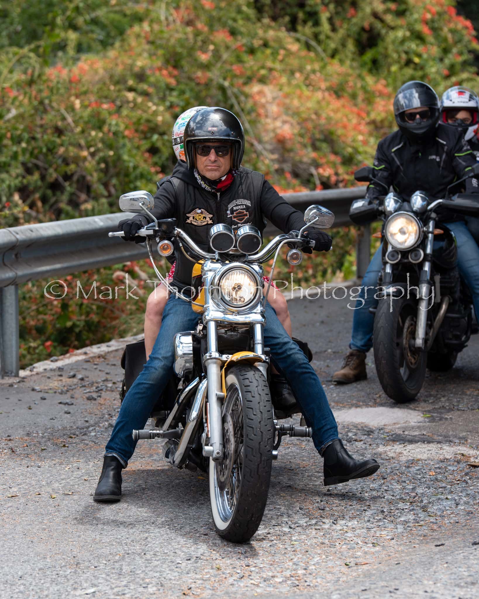 A group of people are riding motorcycles down a road.