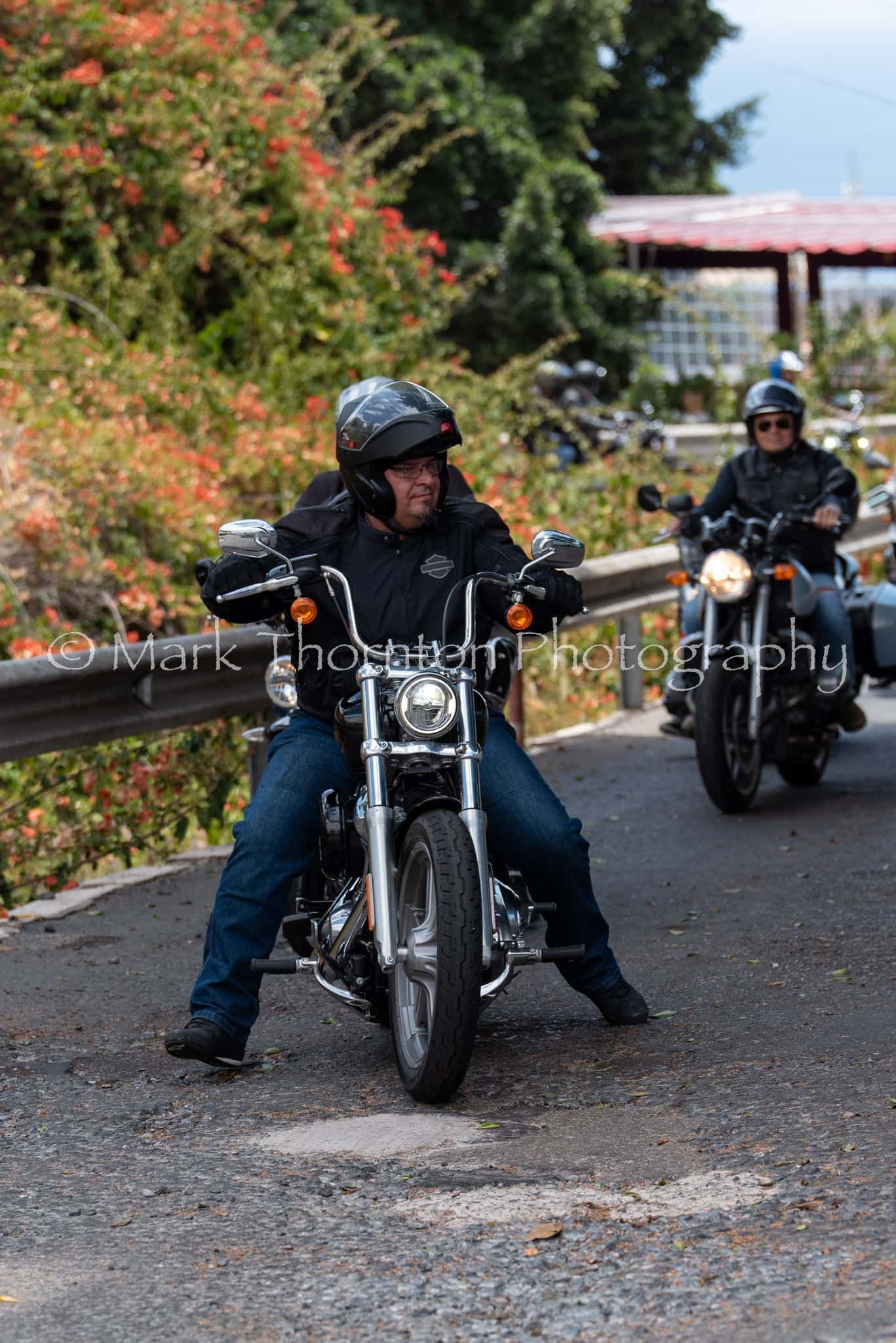 A man is riding a motorcycle down a road.
