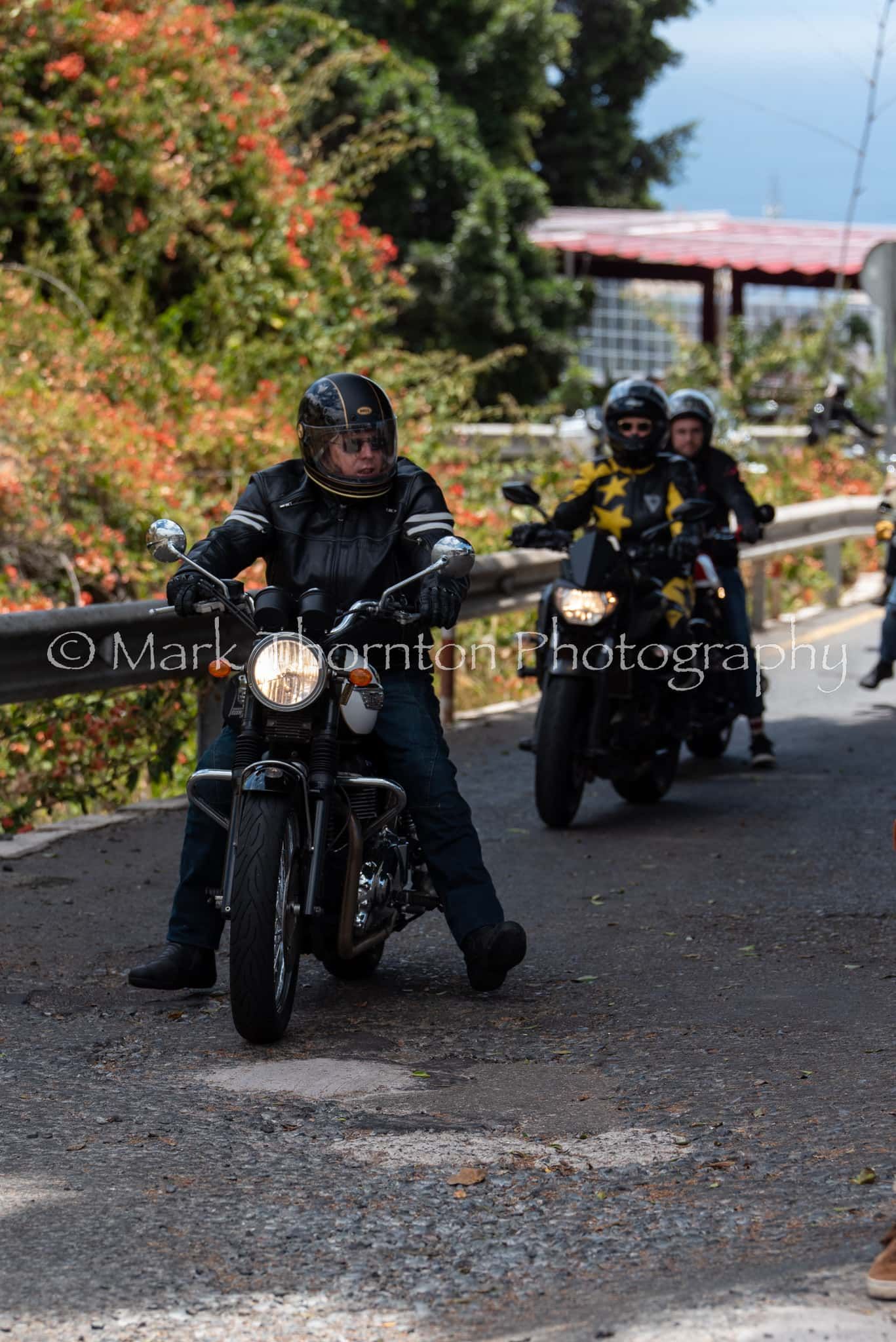 A group of people are riding motorcycles down a road.