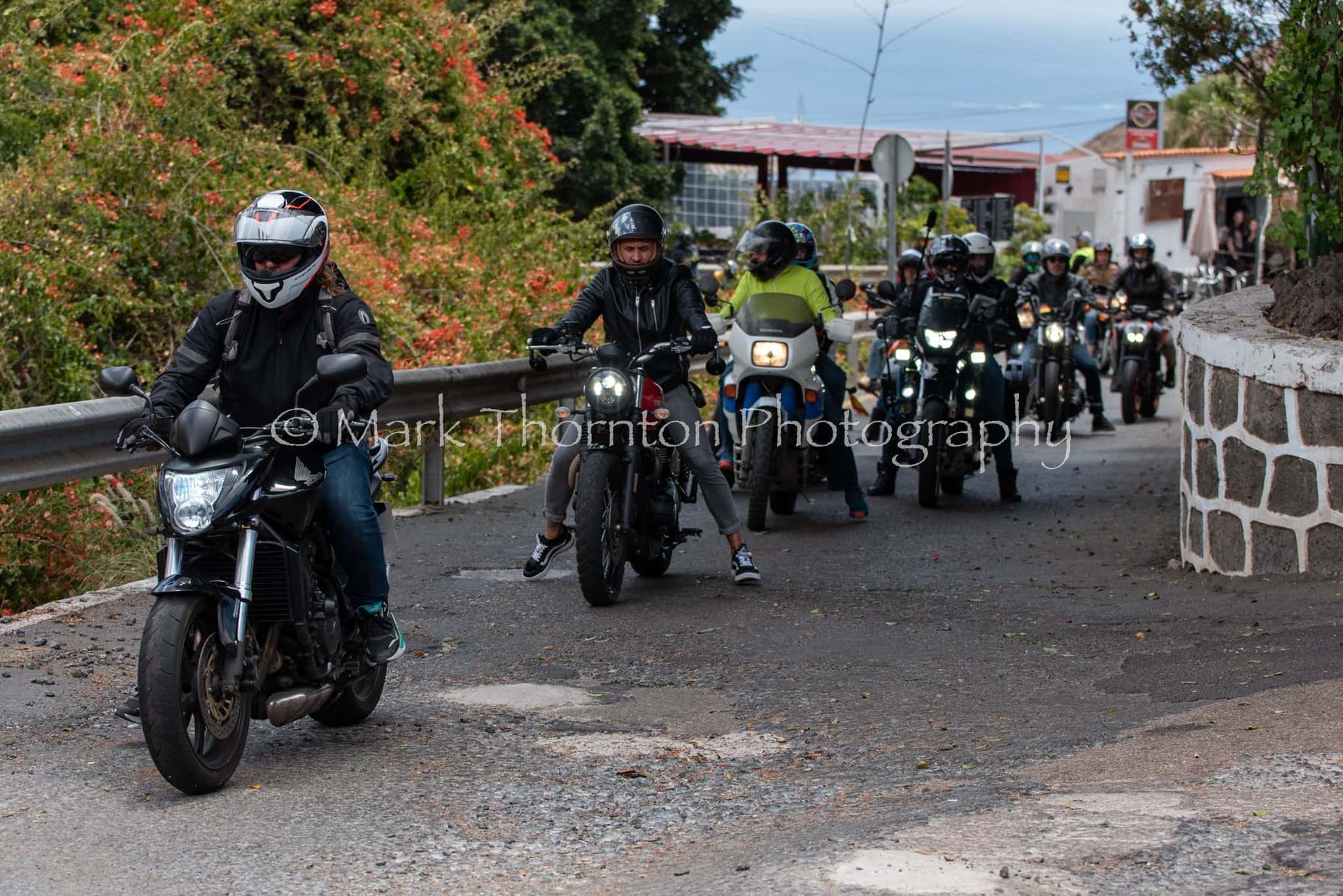 A group of people are riding motorcycles down a road