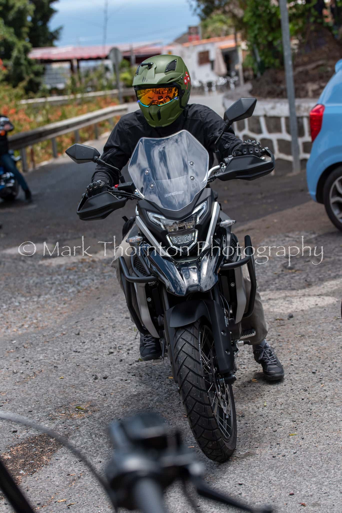 A man is riding a motorcycle down a road.