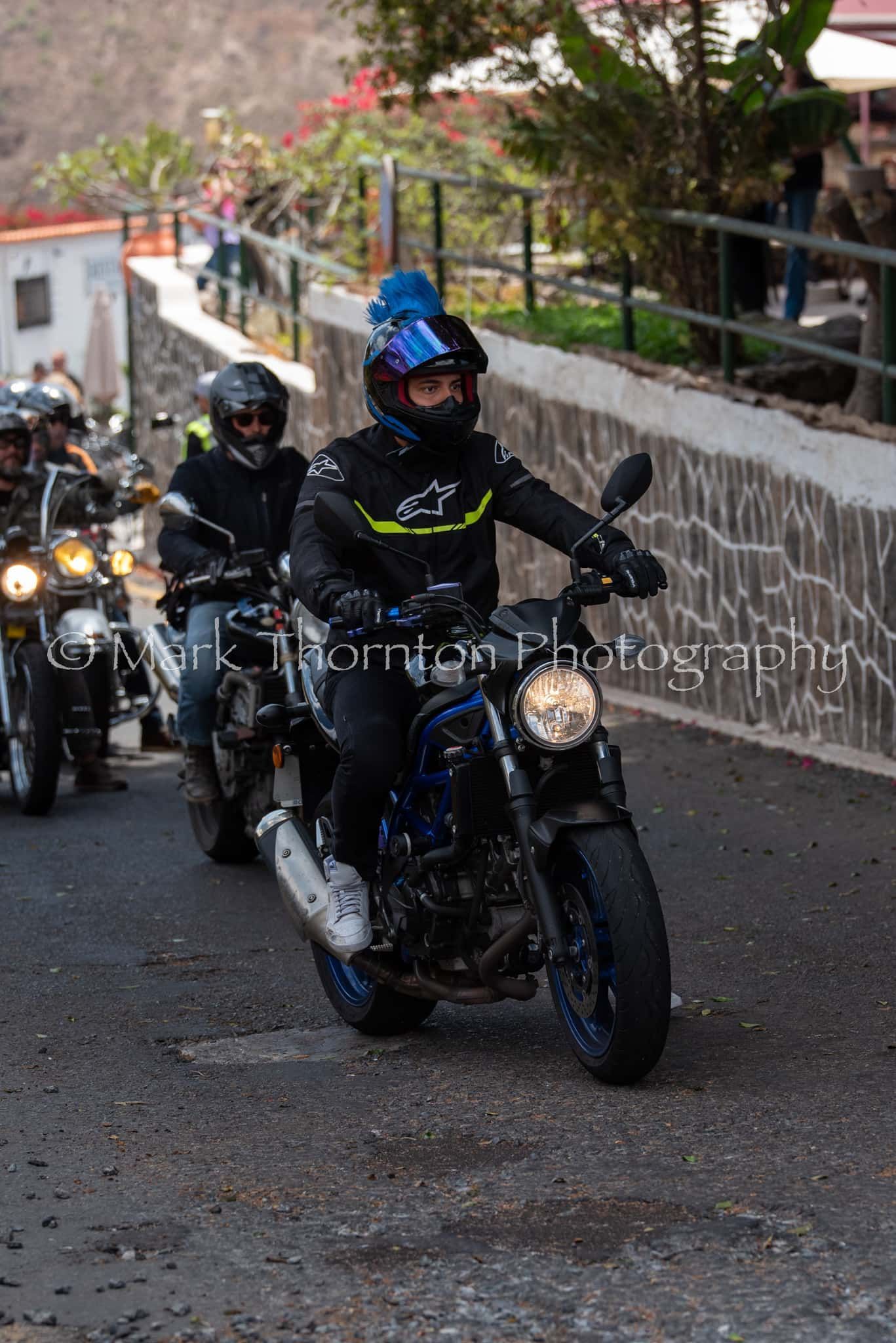 A group of people are riding motorcycles down a street.
