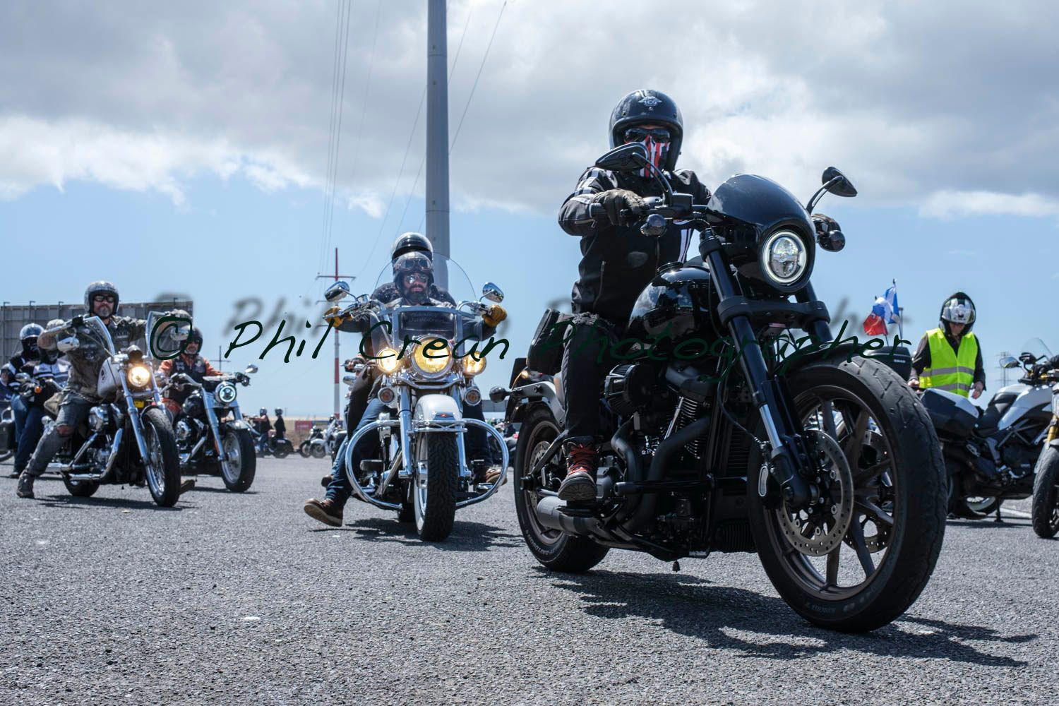 A group of people are riding motorcycles down a road.