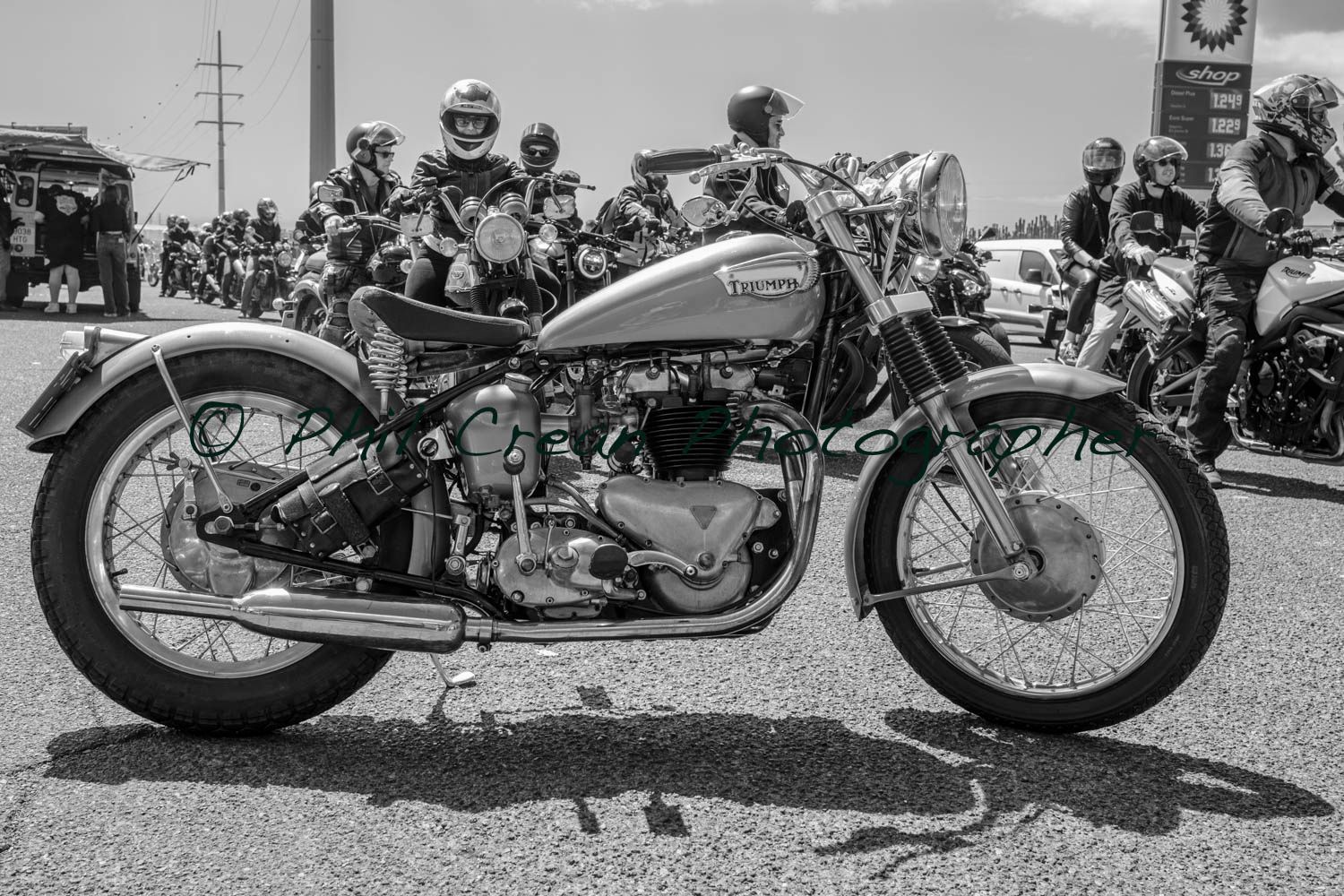 A black and white photo of a motorcycle parked on the side of the road.