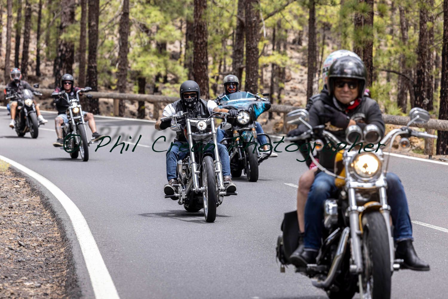 A group of people are riding motorcycles down a road