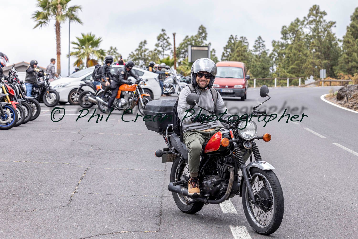 A man is riding a motorcycle down a road
