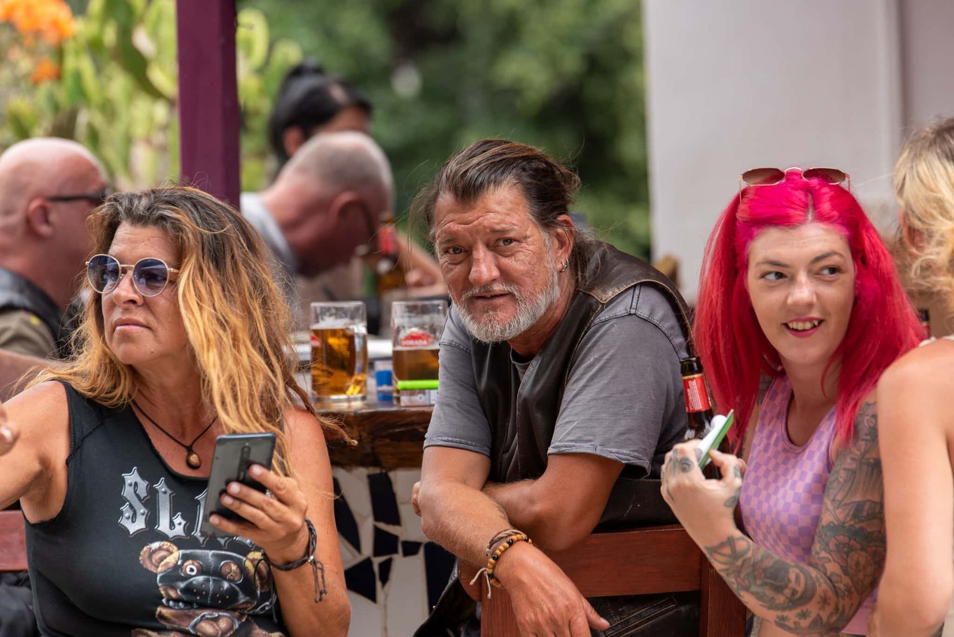 A group of people are sitting at a table looking at their phones.