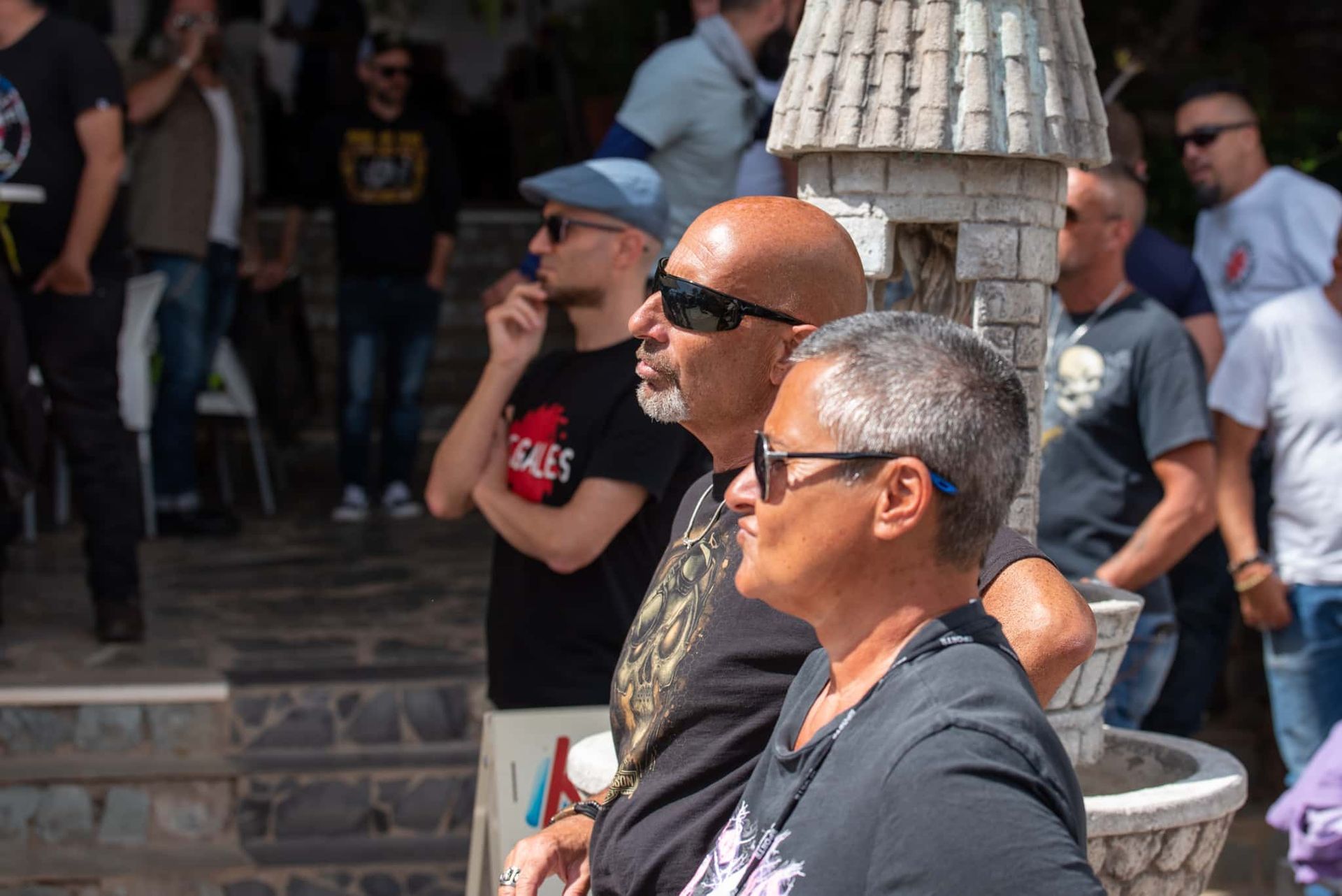 A group of people are standing in front of a fountain.