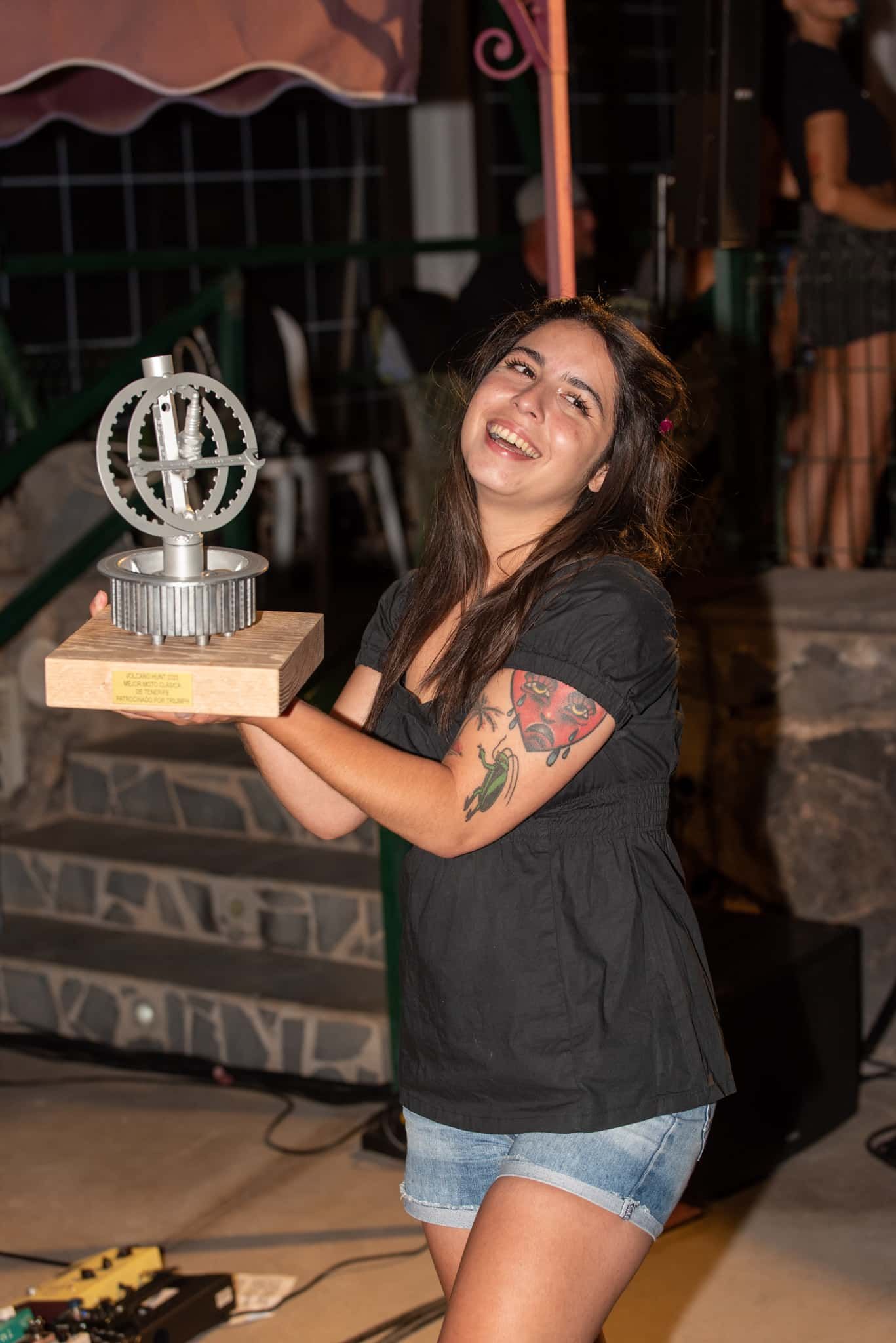 A woman is holding a trophy in her hands and smiling.