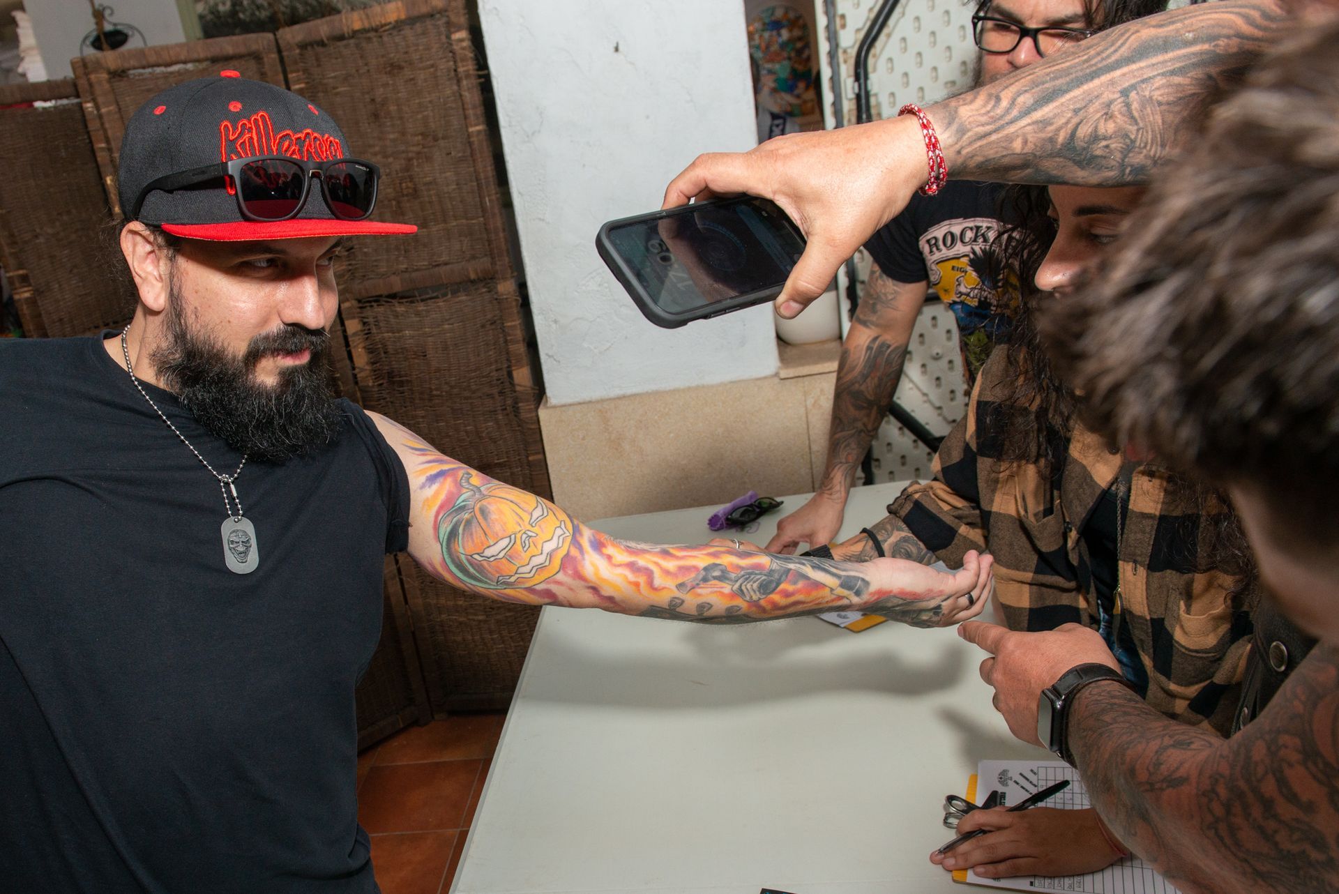 A man with a tattoo on his arm is being photographed by a group of people.