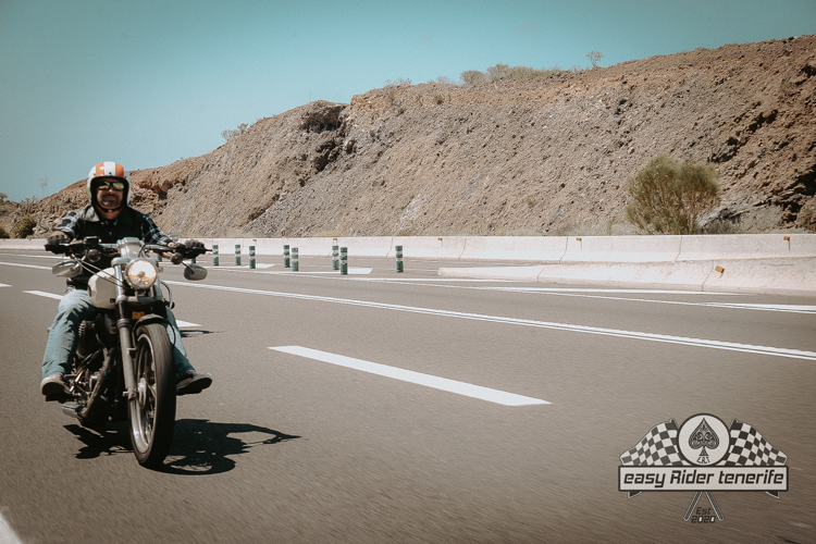 A man is riding a motorcycle down a highway.