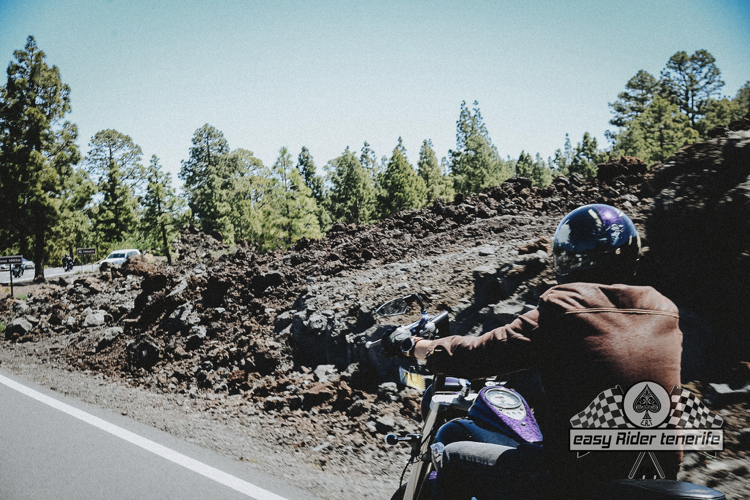 A person riding a motorcycle on a road with a logo that says pneu airbag