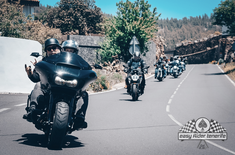 A group of people are riding motorcycles down a road with a logo that says party rider