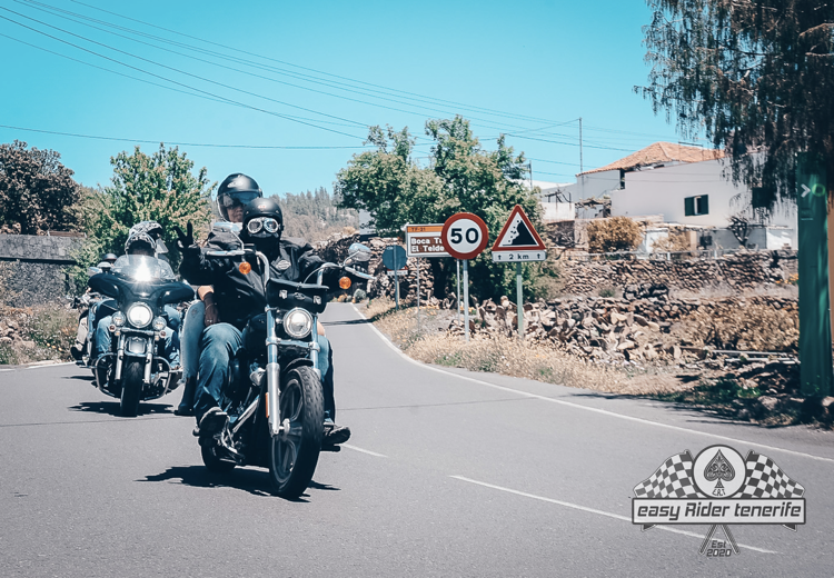 A group of people are riding motorcycles down a road.