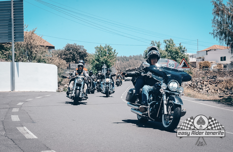 A group of people are riding motorcycles down a road.