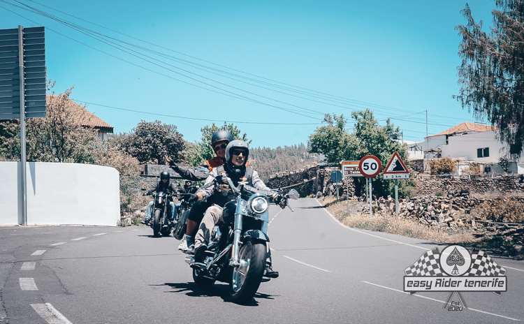 A group of people are riding motorcycles down a road.