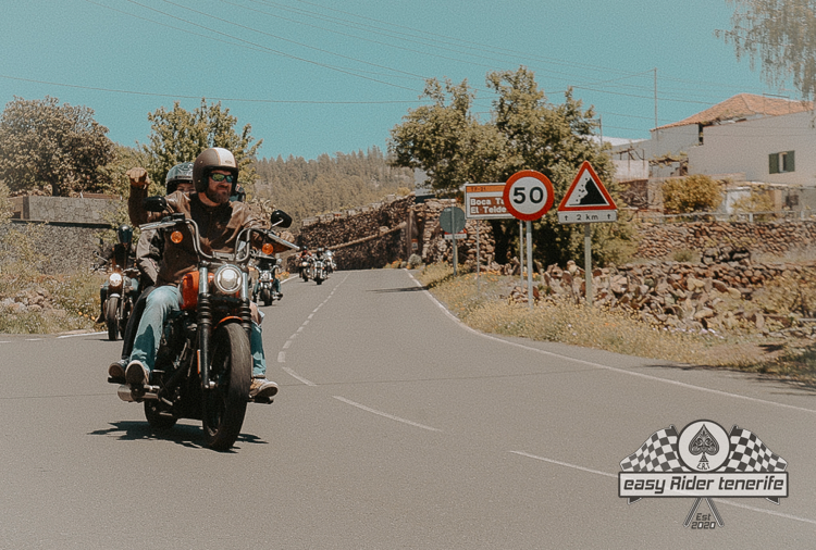 A group of people are riding motorcycles down a road.