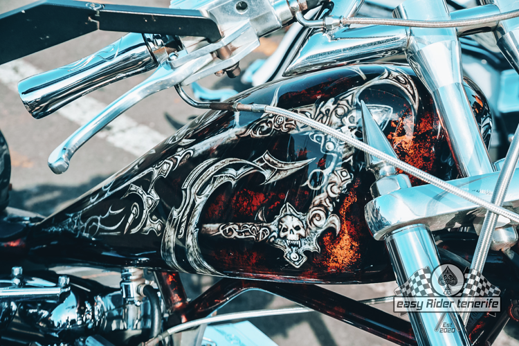 A close up of a motorcycle with a skull on the tank