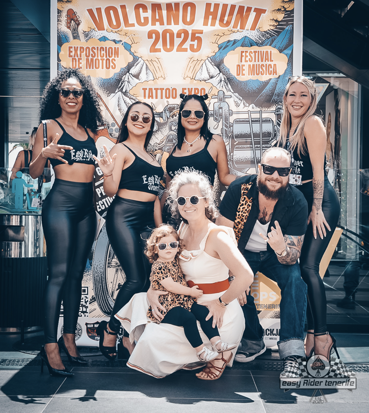 Group poses in front of a poster for 