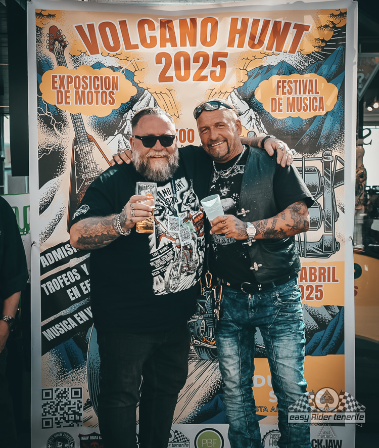 Two men standing in front of a poster that says volcano hunt 2025