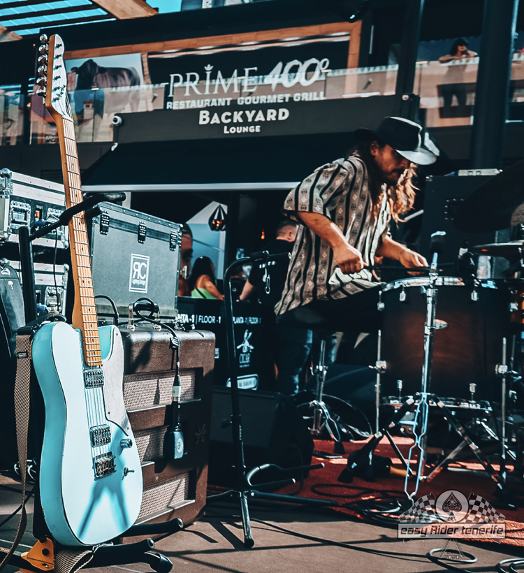 A man playing drums in front of a sign that says prime 400
