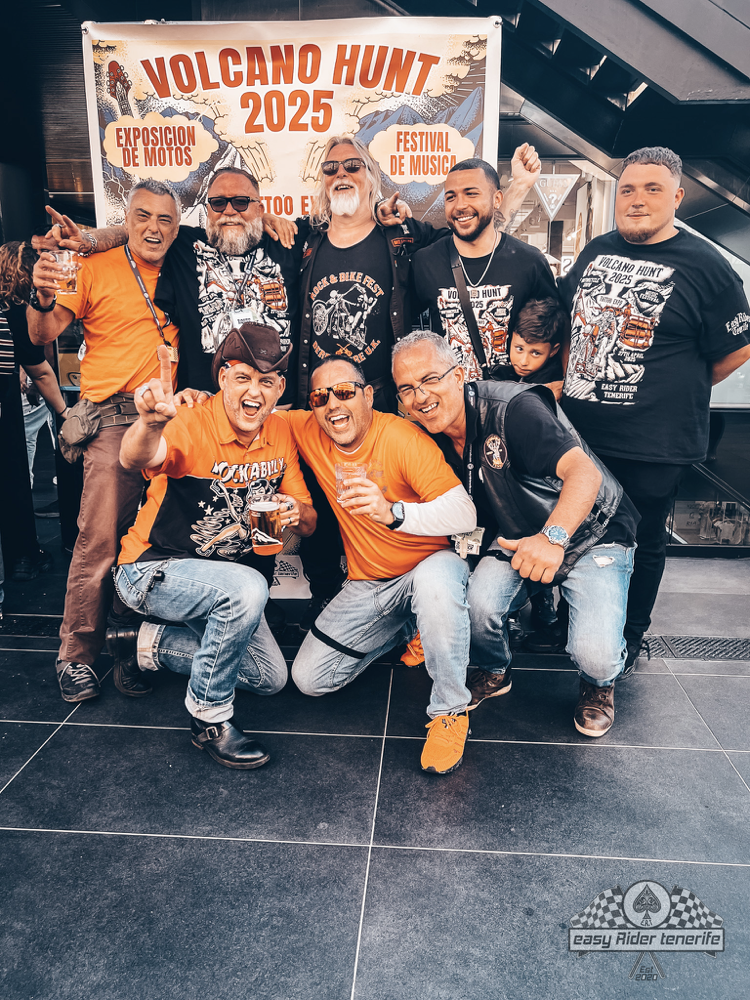 A group of men are posing for a picture in front of a sign that says volcano hunt 2025