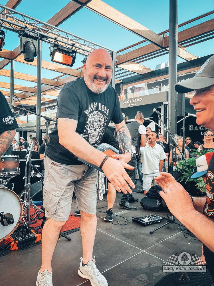 A man with a beard is shaking hands with another man on a stage.