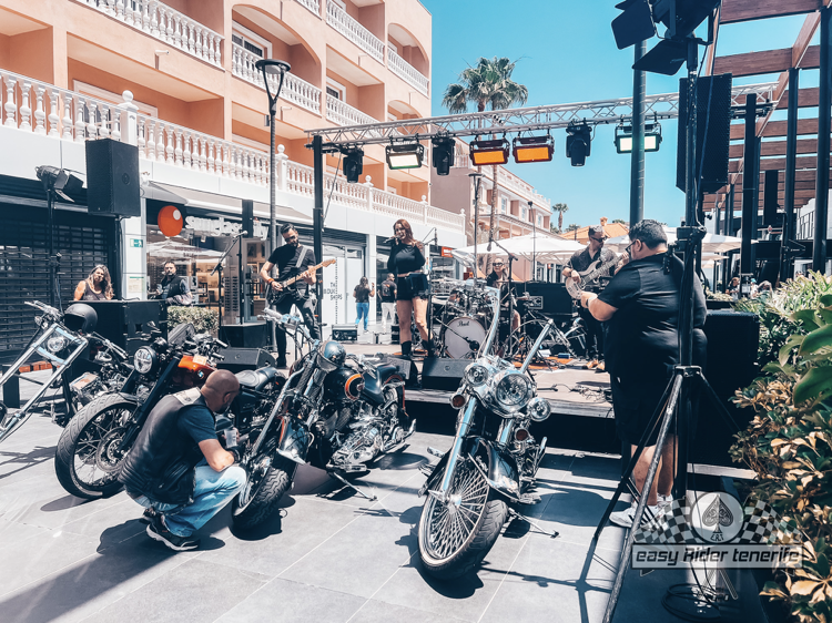A group of motorcycles are parked in front of a stage.