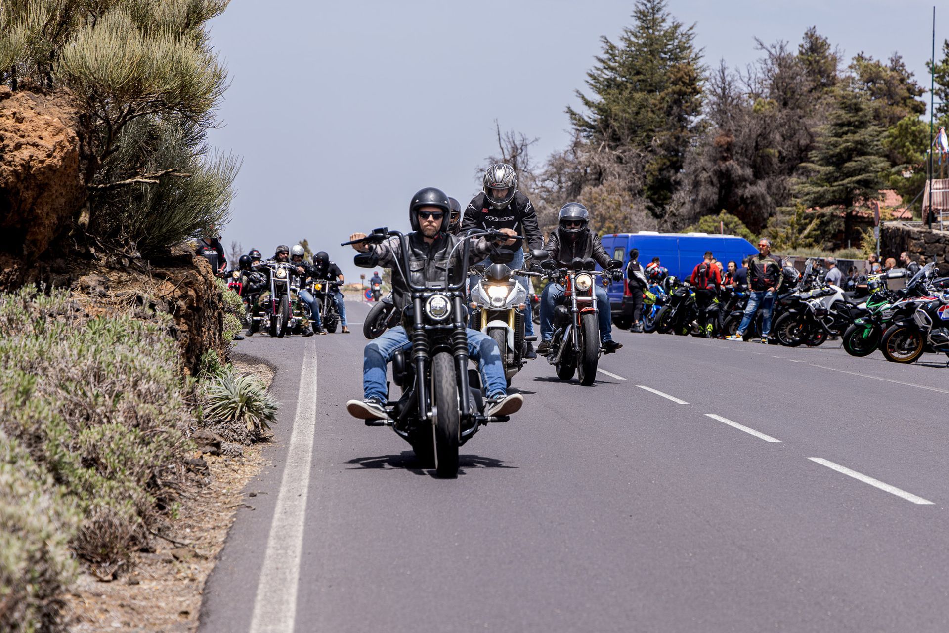 A group of people riding motorcycles down a road