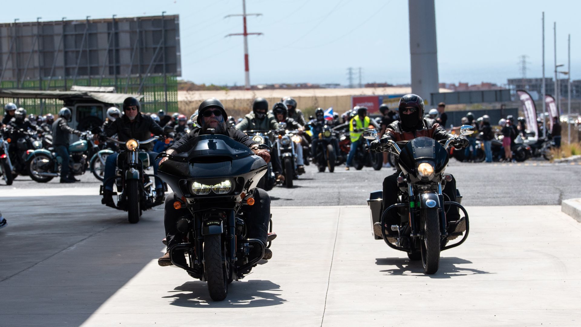 A group of people are riding motorcycles down a street