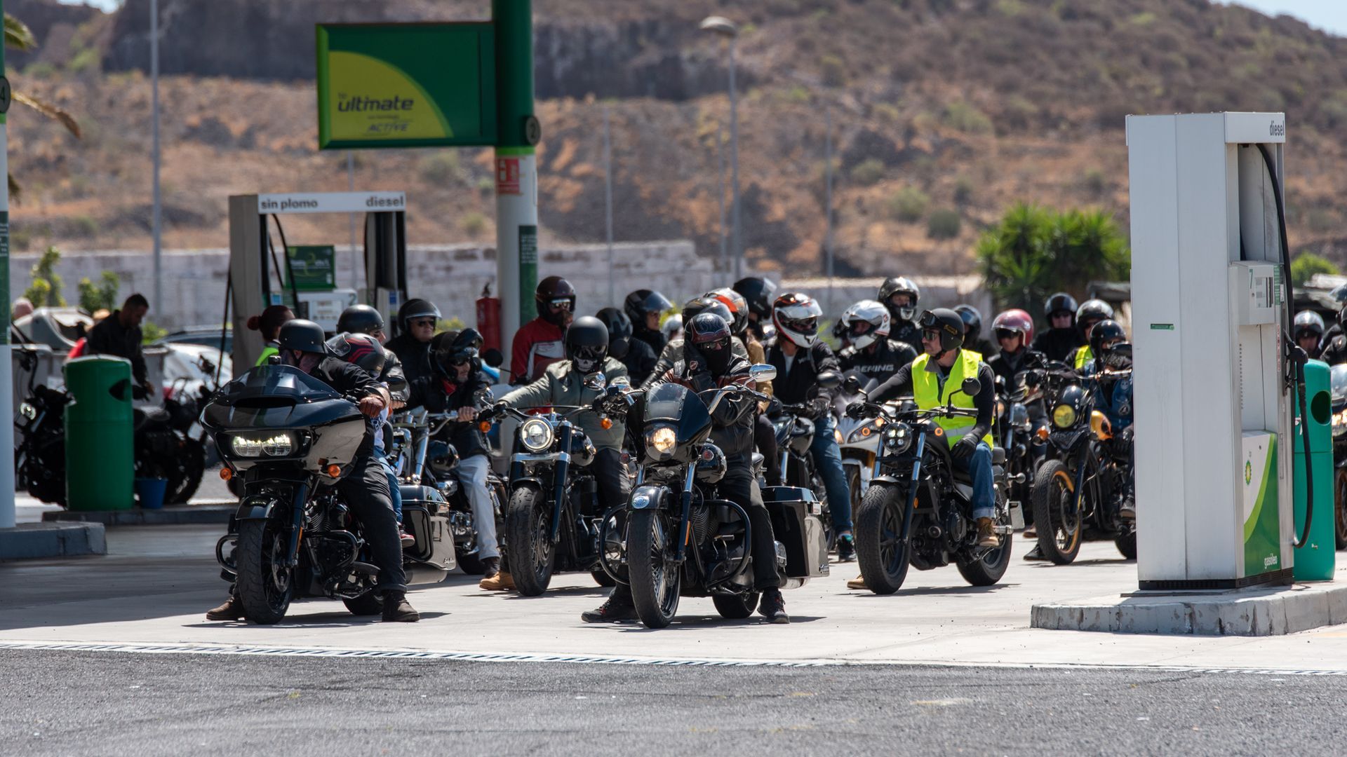 A group of motorcycles are parked in front of a gas station.