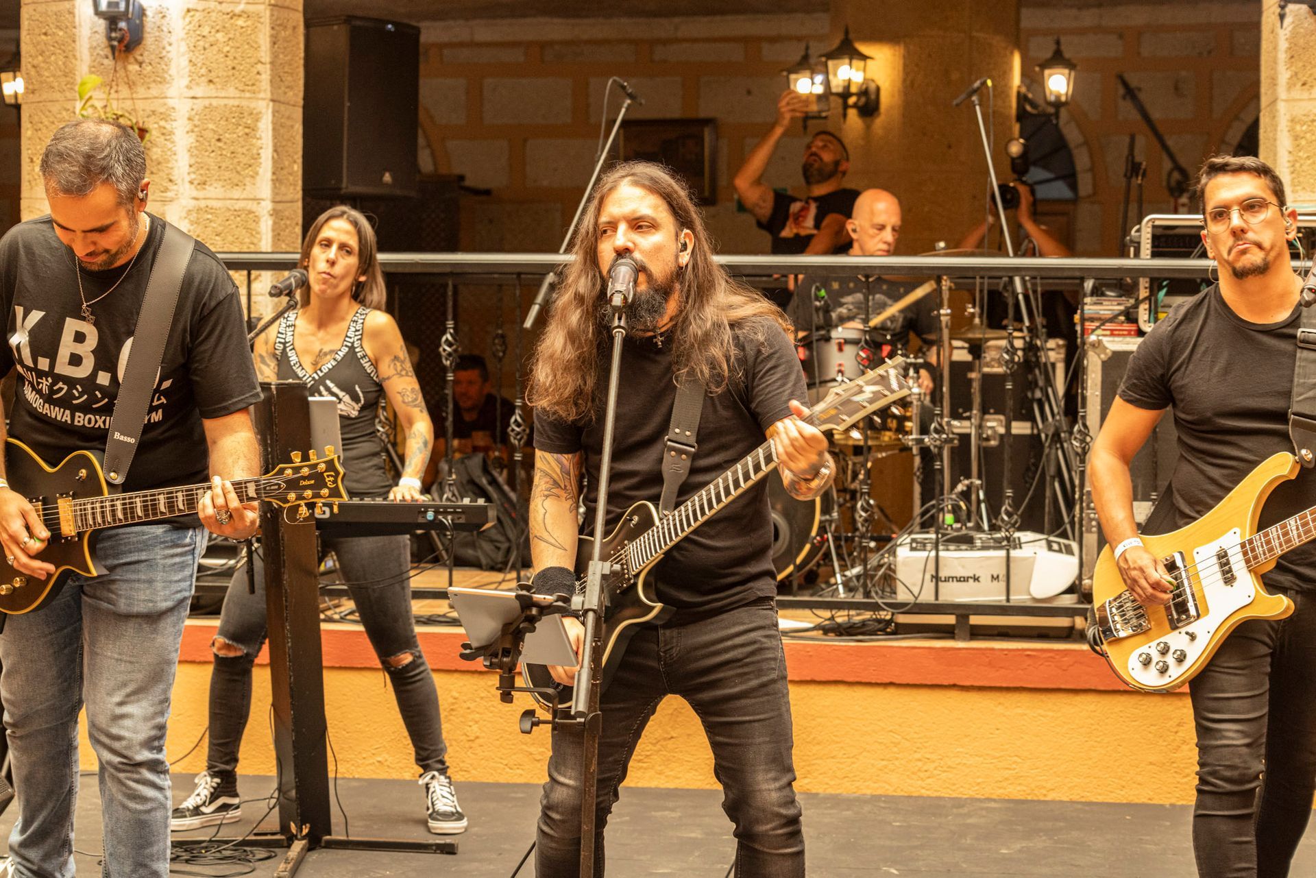 A group of people are playing guitars and singing into microphones.