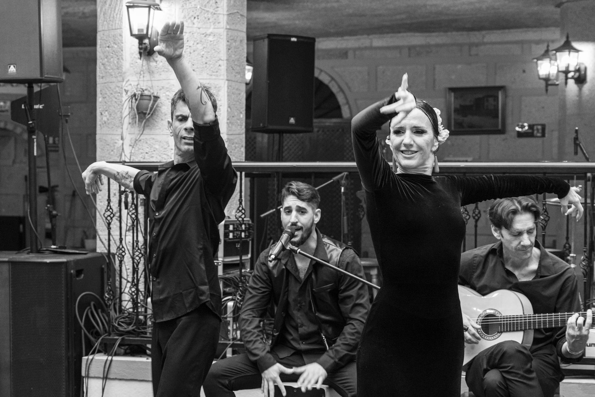 A group of people are dancing and playing guitars in a black and white photo.