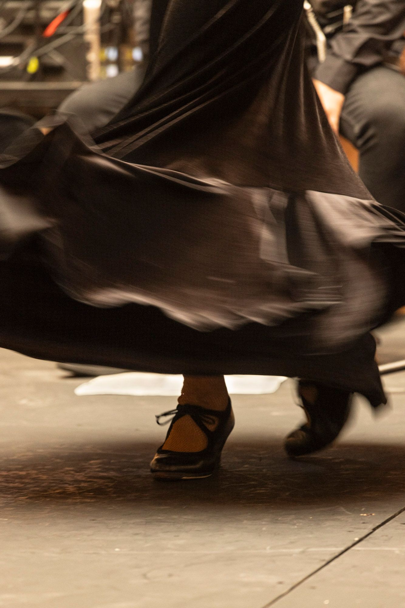 A woman in a long black dress is dancing