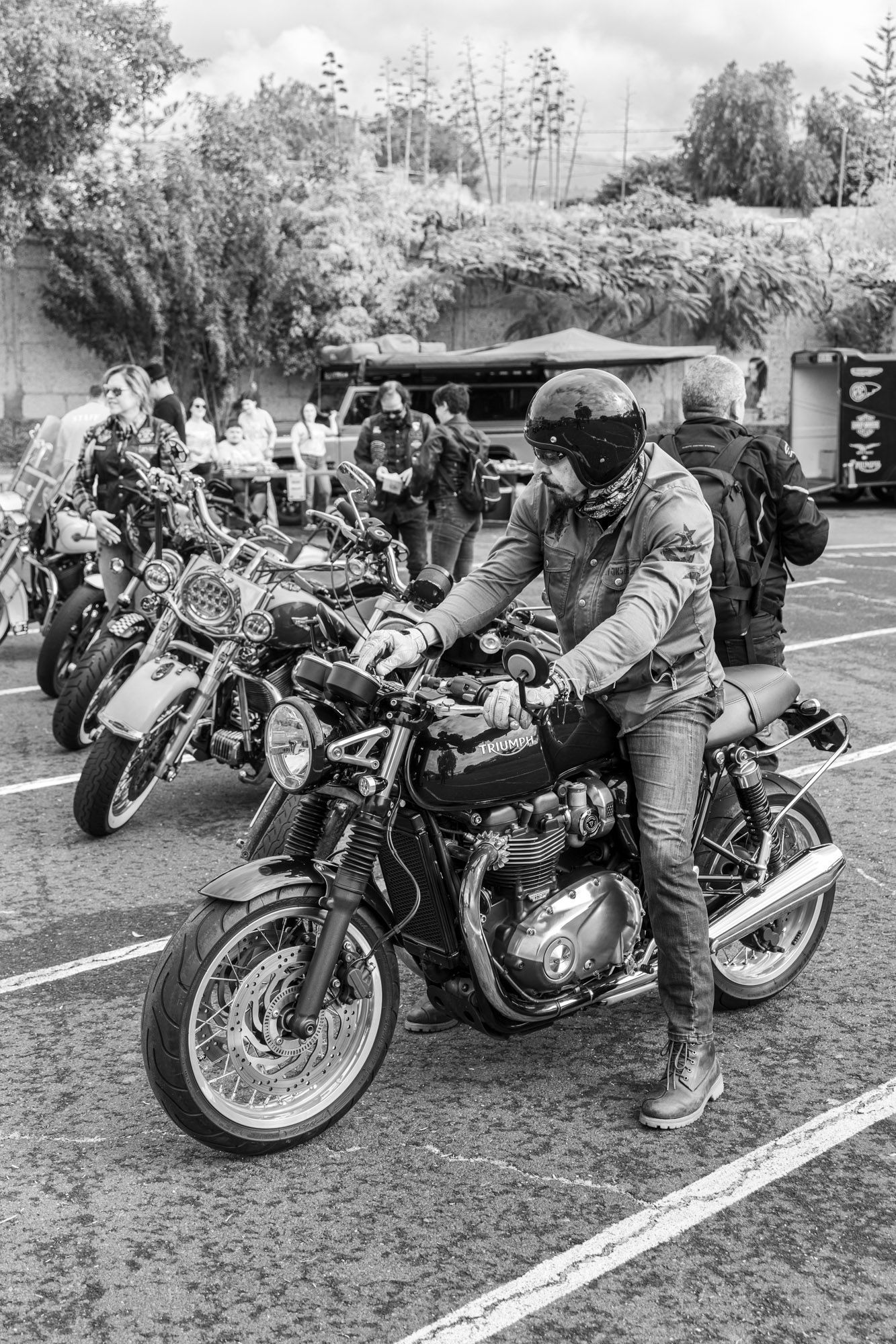 A man is riding a motorcycle in a parking lot.