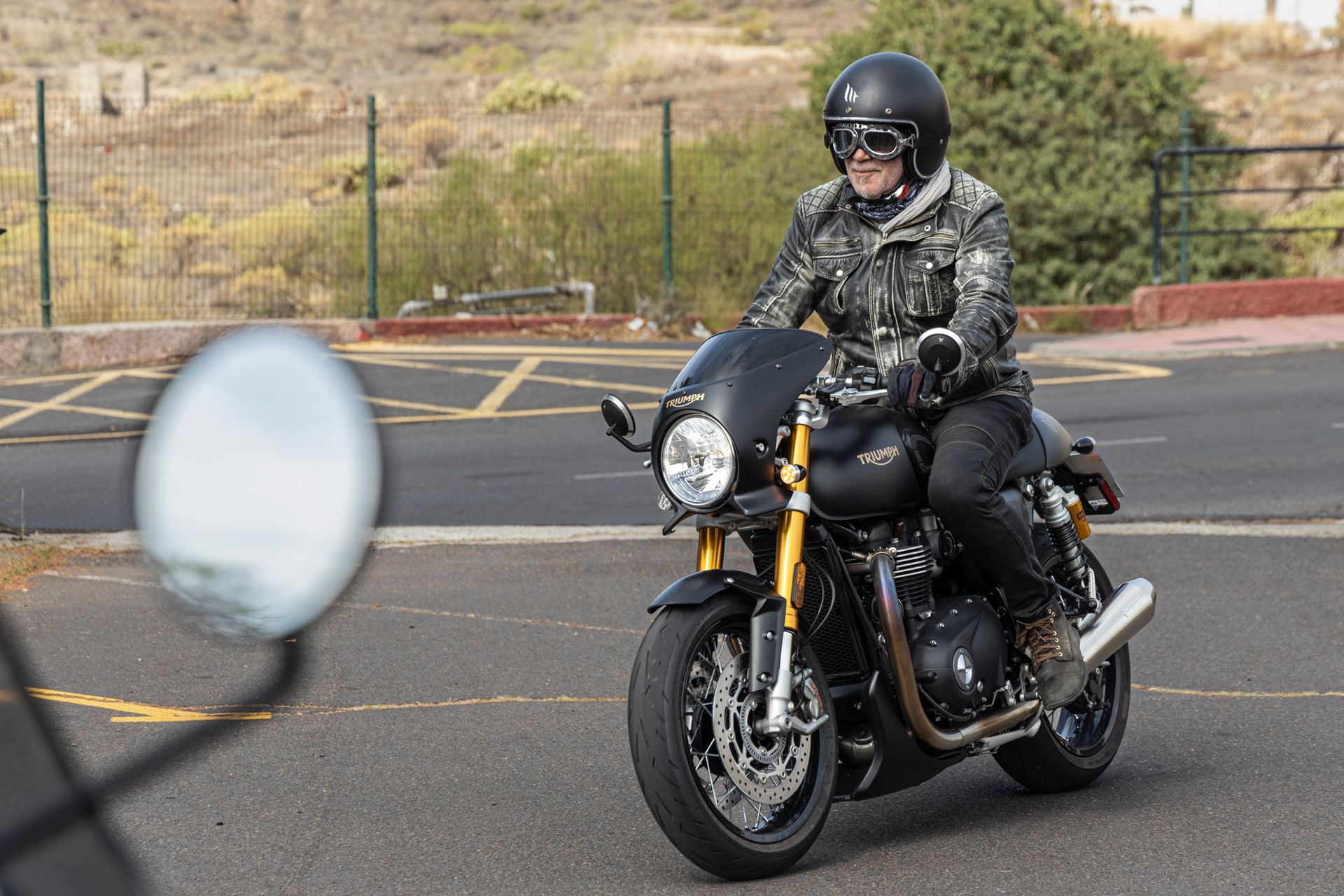 A man is riding a motorcycle down a road.