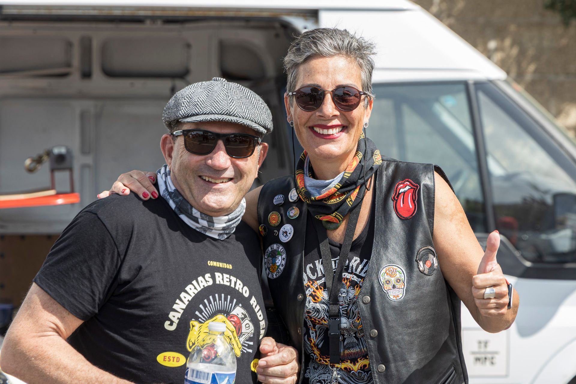 A man and a woman are posing for a picture in front of a van.