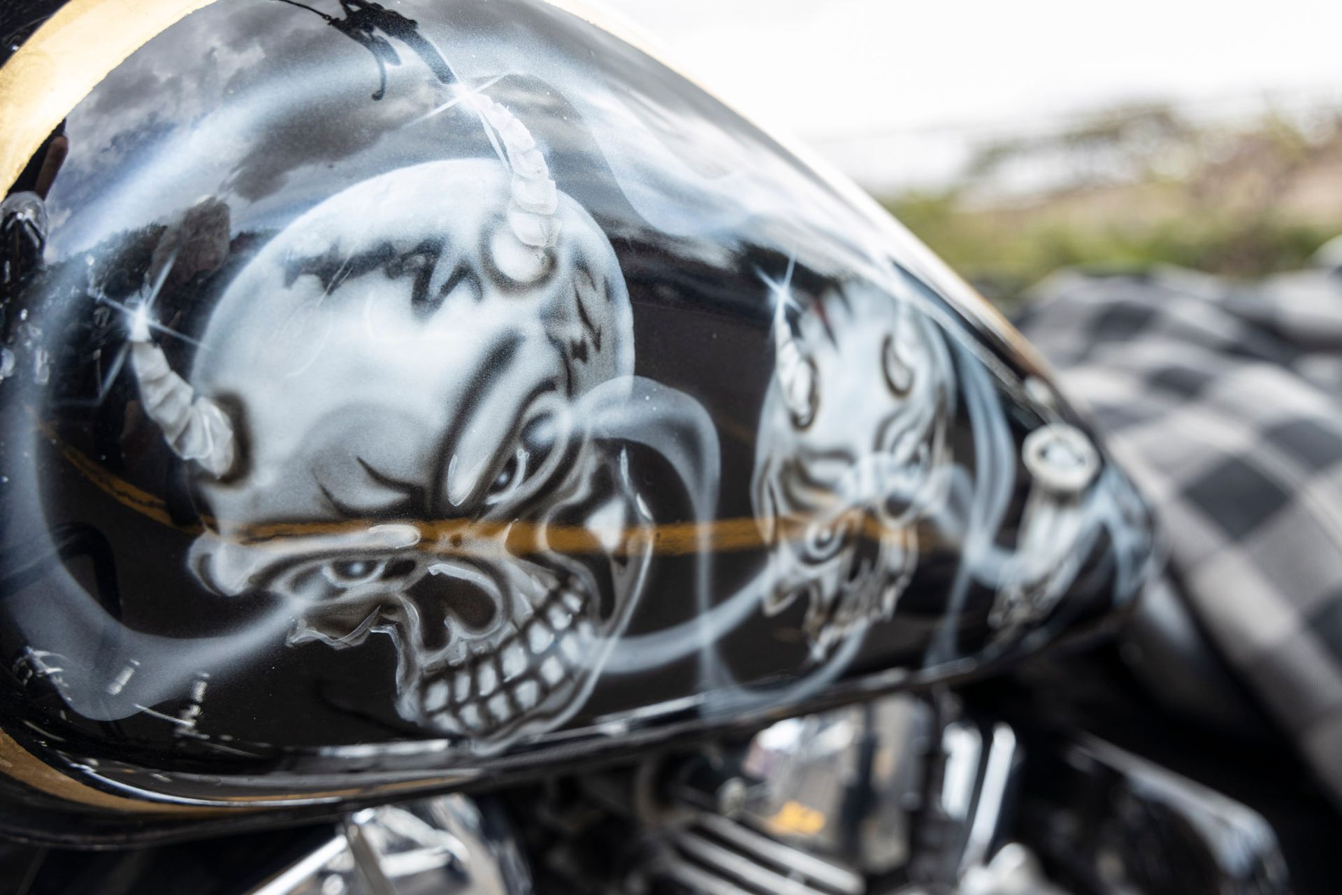 A close up of a motorcycle tank with a skull on it