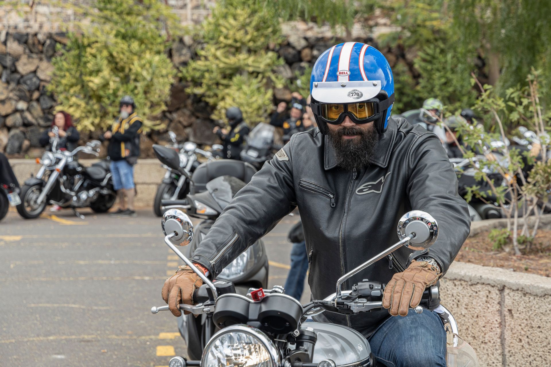 A man wearing a blue helmet and goggles is riding a motorcycle.