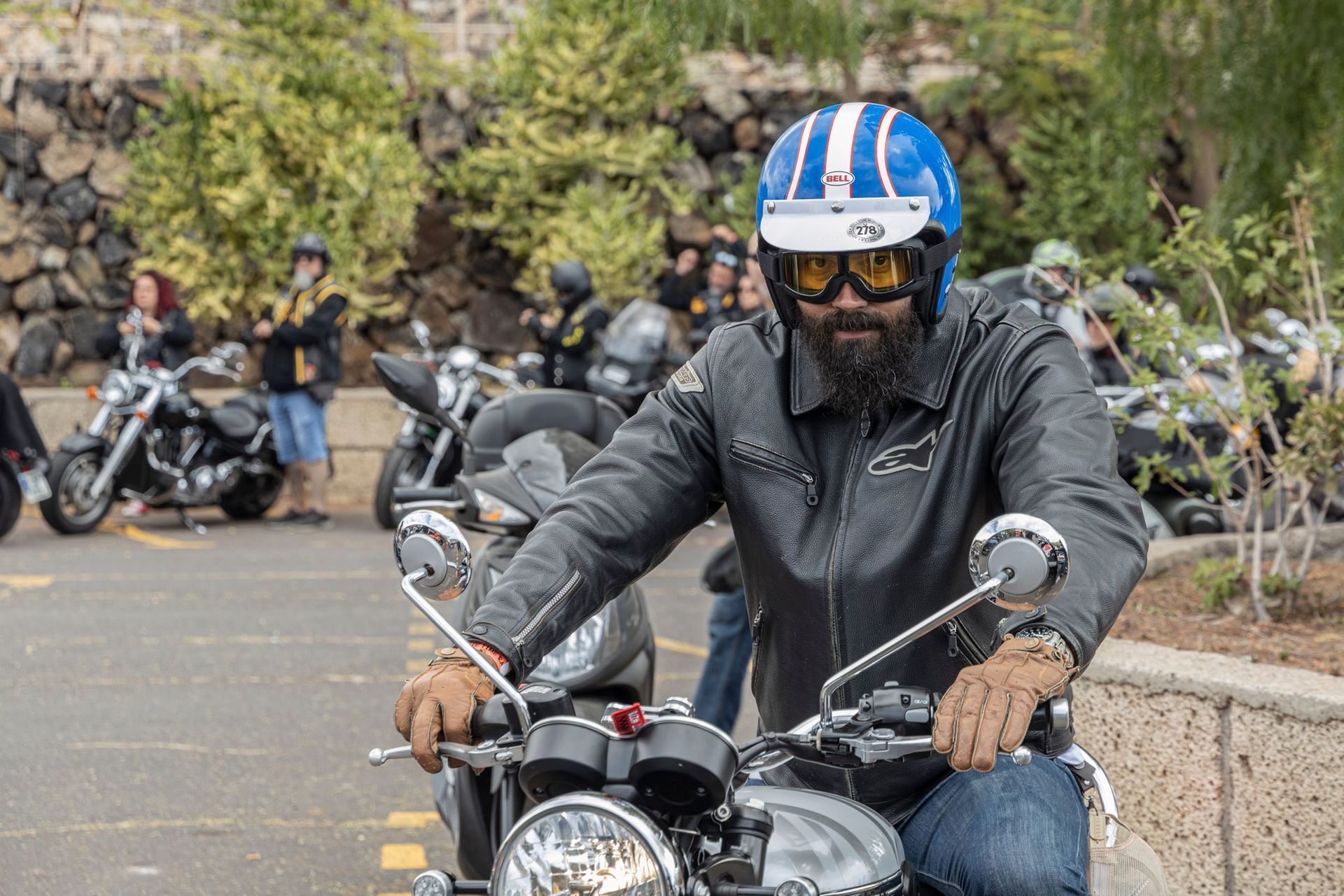 A man wearing a blue helmet and goggles is riding a motorcycle.