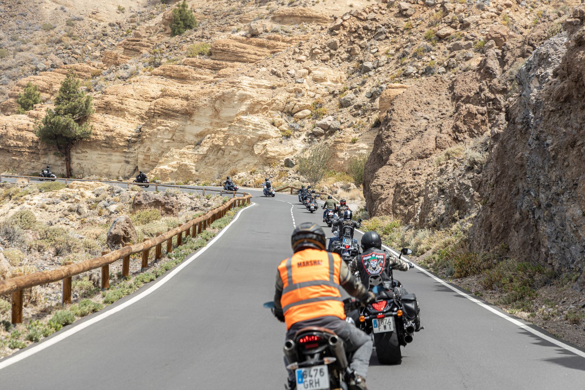 A group of people are riding motorcycles down a road.